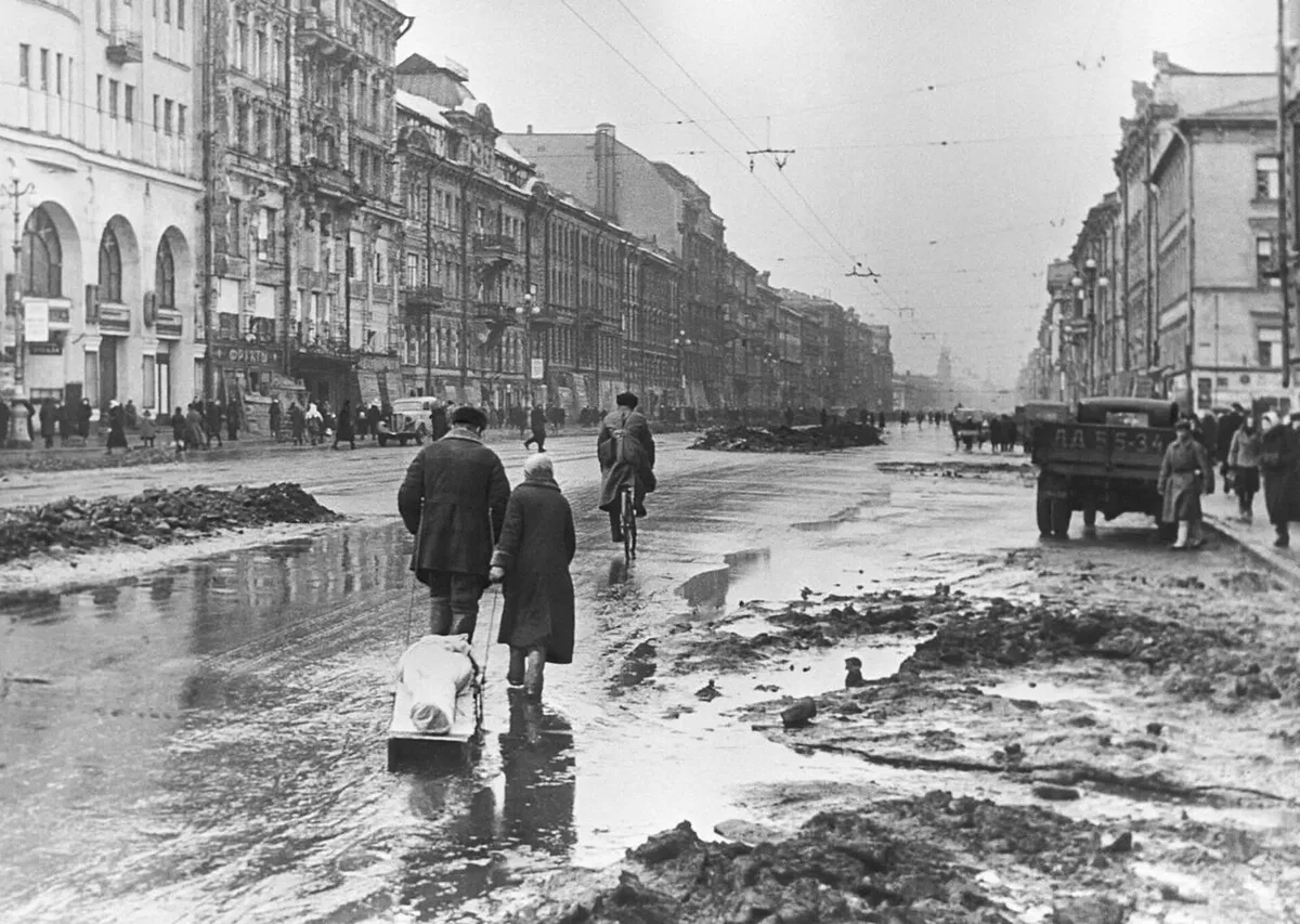 Невский проспект в блокадном Ленинграде: жители везут груз на санках, мостовая разбита обстрелами. Город с почти 2,5-миллионным населением оказался в кольце 8 сентября 1941 года