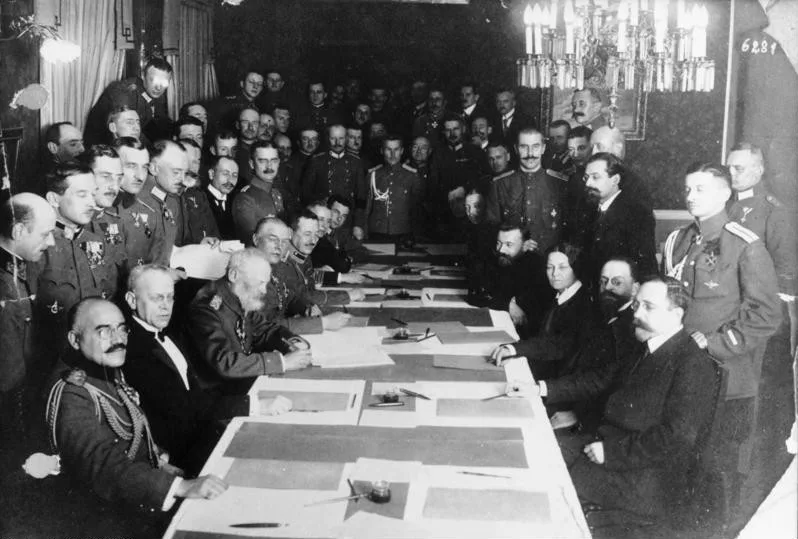 За столом переговоров в Брест-Литовске, 1918 год. Слева — делегации Германии и её союзников, справа — советская делегация. 3 марта 1918 года здесь был подписан Брестский мир